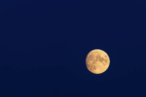 istock Full yellow moon on dark blue sky in right bottom corner 1354497316