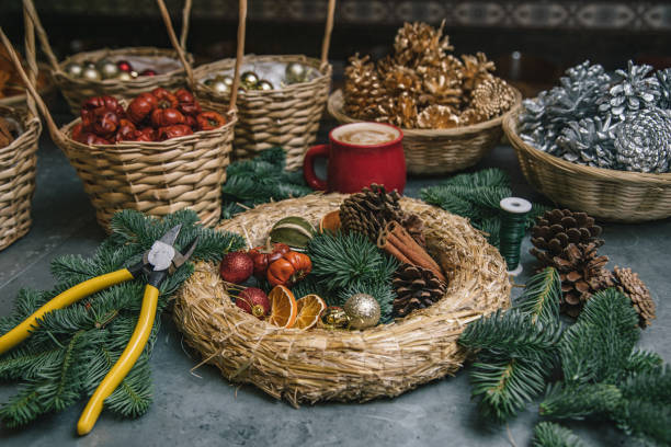 istock Making Christmas door wreath with equipments in decorator's workplace 1354498096