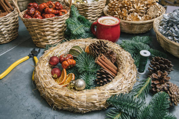 how to learn to make a sustainable Christmas door wreath DIY with moss and dry hortensia flowers in florist work making craft class. Equipment is on the table with a cup of coffee.