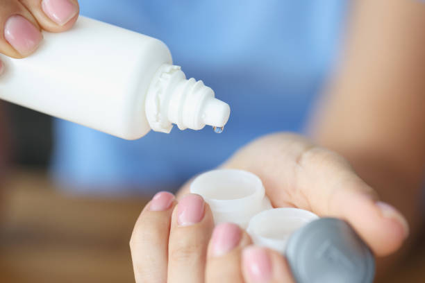 istock Woman pouring lens liquid into plastic container closeup 1354514648