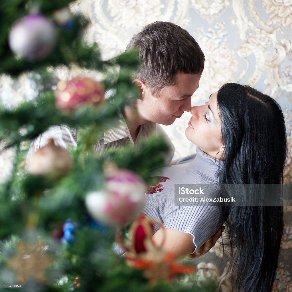 Happy young couple at Christmas Happy young woman and man in domestic room on Christmas day 20-29 Years Stock Photo