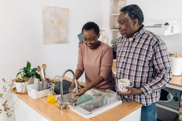 portrait of a happy senior african american couple in the kitchen - senior getting groomed studio imagens e fotografias de stock