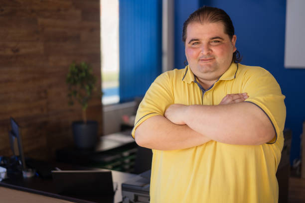 istock Overweight man standing with arms crossed 1354523102