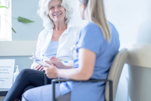 istock Senior in the Waiting Room with a Nurse 1354523886