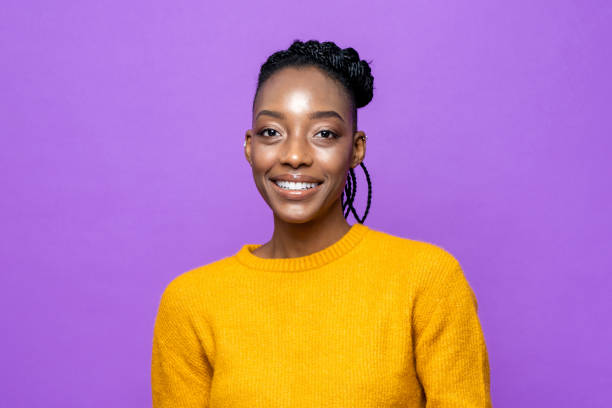casual donna afroamericana sorridente in studio viola sfondo isolato - sfondo a colori foto e immagini stock