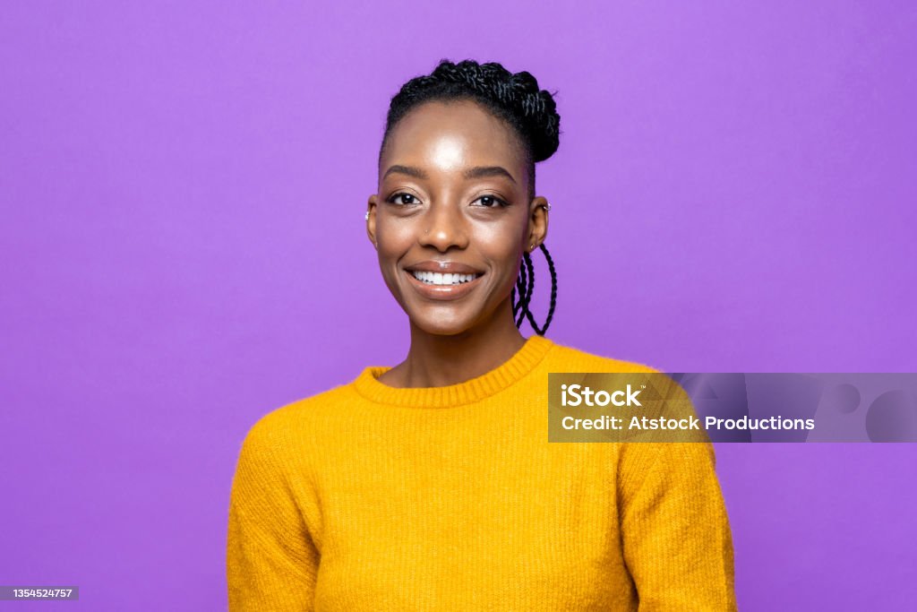 Casual African American woman smiling in purple studio isolated background Portrait Stock Photo