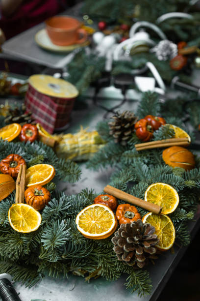 istock Making Christmas door wreath with equipments in decorator's workplace 1354524841