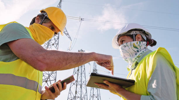 istock High voltage engineers working on the field in COVID-19. Teamwork. 1354524961