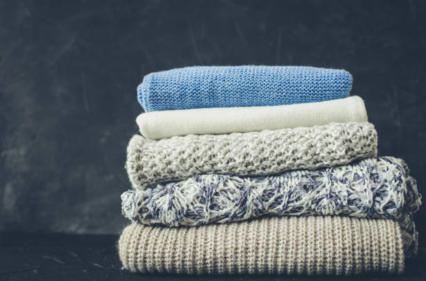 Pile of knitted woolen sweaters Pile of knitted woolen sweaters. Clothes with different knitting patterns folded in stack. Warm cozy winter autumn knitwear concept. Copy space. blanket stock pictures, royalty-free photos & images