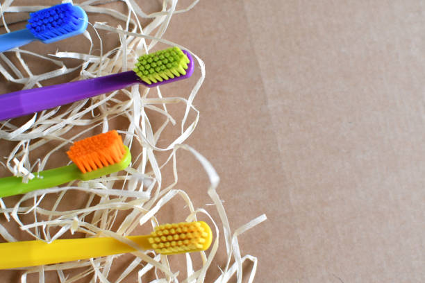 istock Close up of four multicoloured toothbrushes on tile floor. Copy space. 1354526253