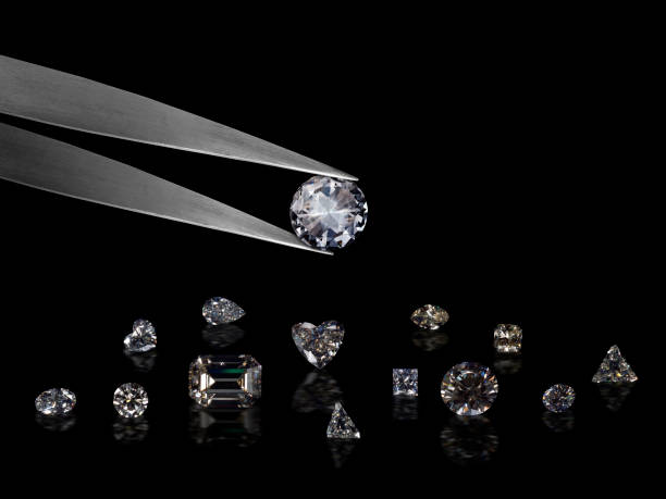 istock Diamond in tweezers on a black background with diamonds group soft focusing 1354527013