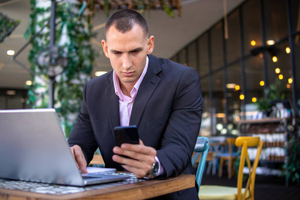 istock Young handsome businessman working on his laptop while sitting in a cafe 1354528633