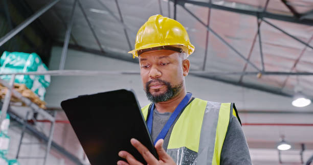 istock Low angle shot of a mature man using a digital tablet while working in a warehouse 1354533630
