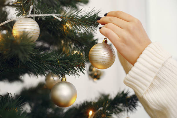 istock Mother with cute daughter standing near christmas tree 1354547963