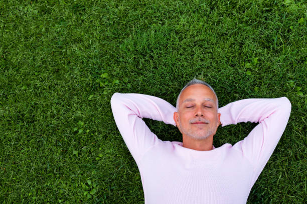 istock Adult caucasian man rest lying on grass with eyes closed. Copy space 1354556631