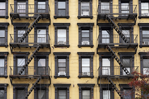 Colorful, Old fashioned Manhattan apartment building facades with external fire escape ladders