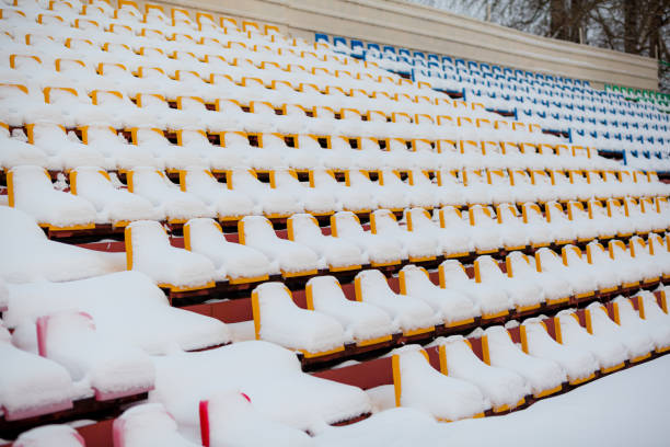 istock Plastic seats in a row at the stadium are covered with snow snow. 1354558428