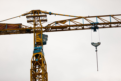 Picture of a construction crane against blue, cloudy sky