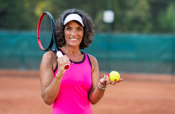 portrait d’une femme âgée active sur un court de tennis - tennis senior adult adult mature adult photos et images de collection
