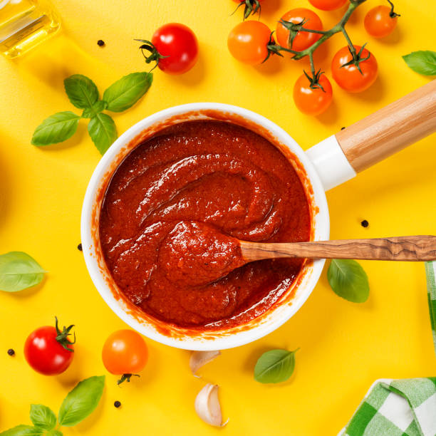 Italian tomato sauce Classic homemade Italian tomato sauce with basil for pasta and pizza. Yellow background. top view marinara stock pictures, royalty-free photos & images