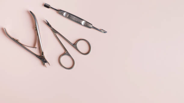 istock Banner manicure tools set of clipper scissors and cuticle pusher on light pink surface. Copy space. 1354577320