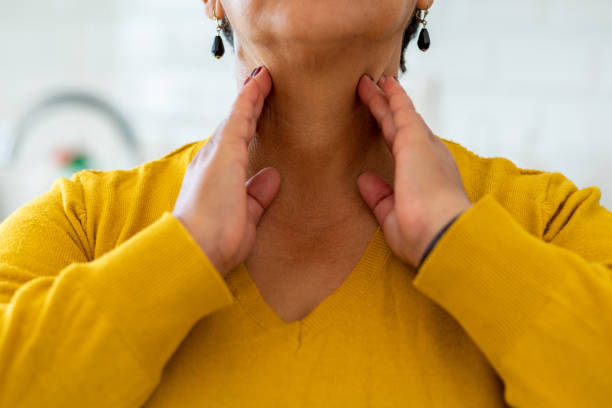 woman with thyroid gland problem - touching neck imagens e fotografias de stock