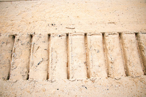 Textural sand, with a relief surface, multi-colored layers and different in size of granules, in an outdoor sand career, after mining ore and sand for construction.