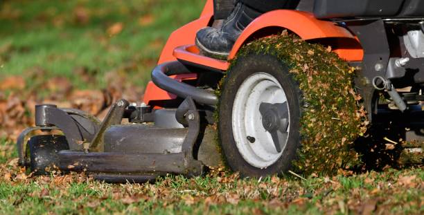 das bett eines orangefarbenen mulchtraktors, der an einem sonnigen herbsttag die herbstblätter auffrischt - lawn mower tractor gardening riding mower stock-fotos und bilder