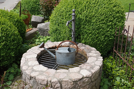 Garden with a stone fountain and watering can