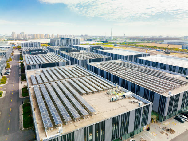 vista aérea de paneles solares en el techo de la fábrica. producto del sistema de paneles solares voltaicos azul brillante. - fábrica fotografías e imágenes de stock