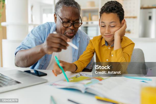 Grandfather Tutoring His Grandson At Home Stock Photo - Download Image Now - Tutor, Child, Grandparent