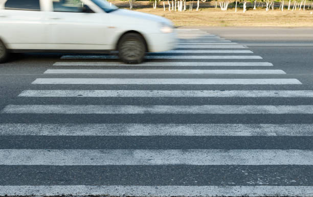 istock Car at high speed passes through a pedestrian Zebra. 1354583002