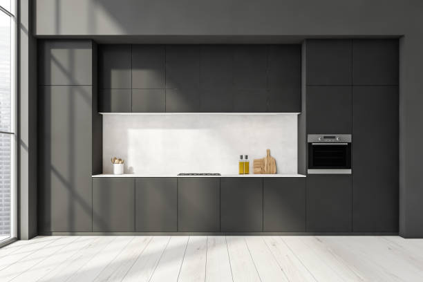 istock Minimalist black kitchen with white backsplash and wood plank floor 1354583846