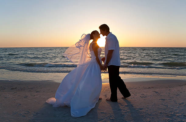 panna młoda & pan młody żonaty para całować zachód słońca plaża ślub - wedding beach bride groom zdjęcia i obrazy z banku zdjęć