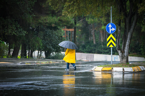 man walking in a yellow raincoat on a rainy day