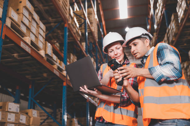istock Two logistic staff in safety suite working at warehouse 1354585613