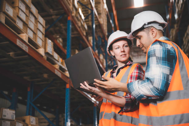 istock Two logistic staff in safety suite working at warehouse 1354585658