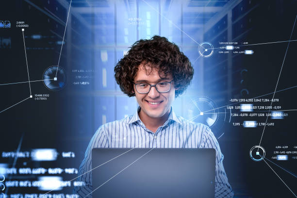 istock Smiling programmer portrait in glasses, sitting in front of lapt 1354585705