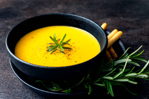istock Pumpkin soup with linen napkin on dark background. 1354586522