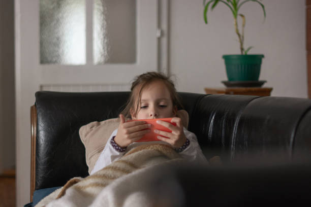 istock Girl at home lying on the couch using smartphone 1354586811