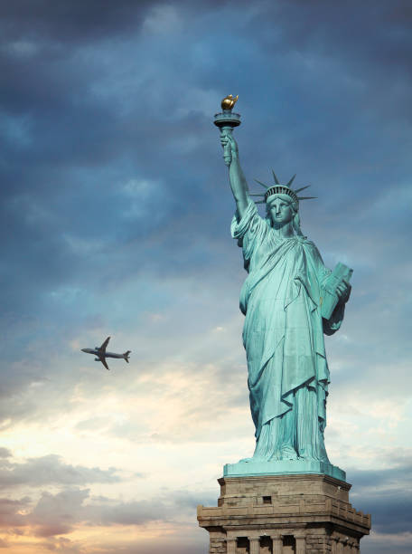 istock Statue of Liberty with flying airplane 1354587369