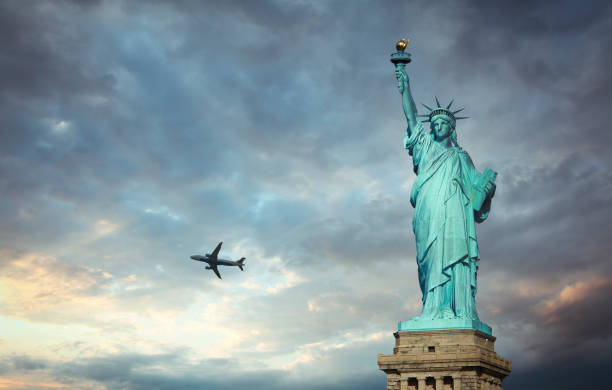 istock Statue of Liberty with flying airplane 1354587371