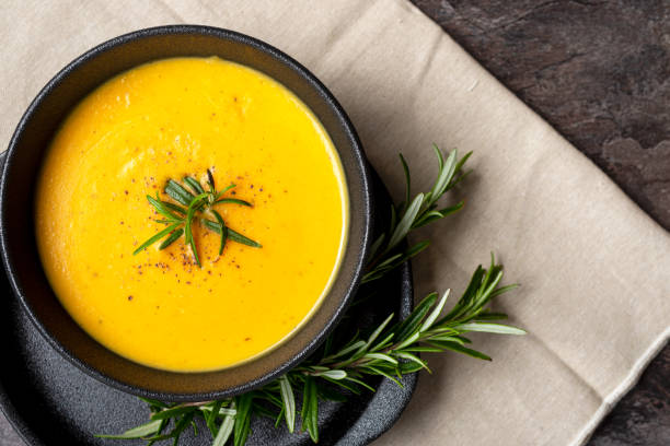 istock Pumpkin soup with linen napkin on dark background. 1354587492