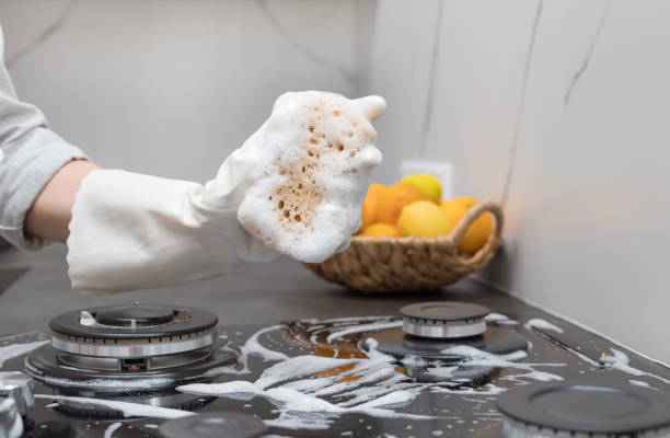 istock Female hand holding sponge with foam on blurred kitchen background 1354587532