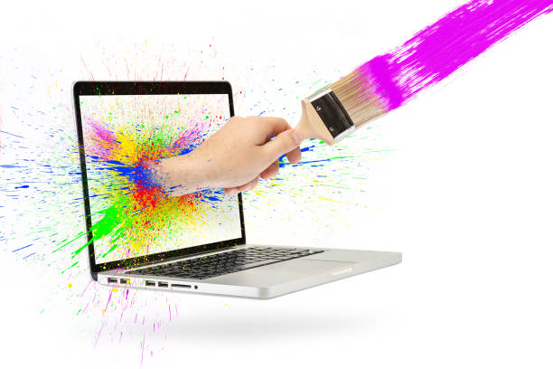 A hand with a paintbrush sticks out of the laptop screen. Isolated on white. Splashes of multi-colored paint in different directions. Concept searching for workers for home renovation on the Internet. una mano con un pincel sobresale de la pantalla de la computadora portátil. aislado sobre blanco. salpicaduras de pintura multicolor en diferentes direcciones. concepto de búsqueda de trabajadores para la renovación del hogar en internet