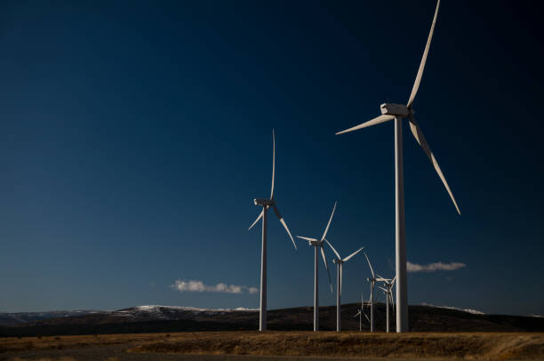 moderne windmühlen im land vor blauem himmel. gedreht in kastilien-la mancha, spanien - green business stock-fotos und bilder