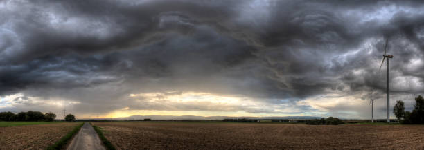 Thunderstorm A thunderstorm roars across the country with wind turbines at the edge of the picture field stubble stock pictures, royalty-free photos & images