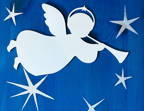 Trumpet playing angel on christmas stars background