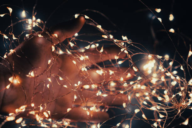 istock hand covered in Christmas lights in the dark 1354607490