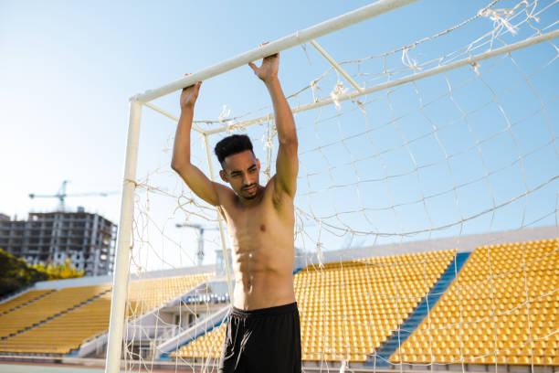 young attractive shirtless african american sportsman near football goal after game at city stadium - football player imagens e fotografias de stock
